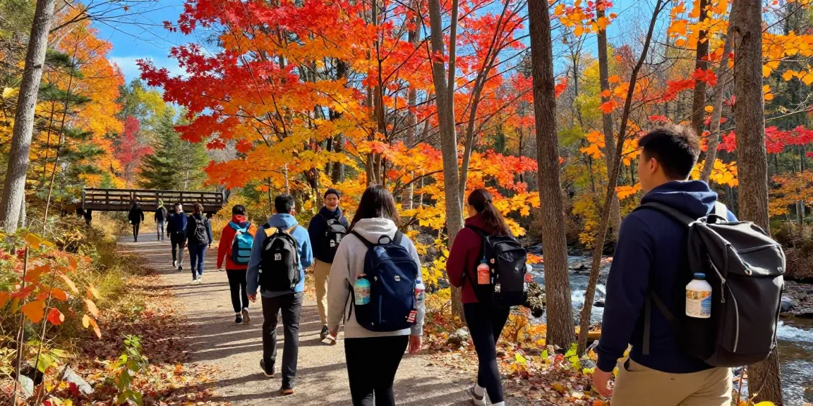 Serge Robichaud hiking with friends in vibrant New Brunswick fall foliage, showcasing outdoor activity and camaraderie.